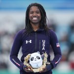 Gold medallist Erin Jackson of Team United States celebrates during the Women's 500m flower ceremony at the 2022 Winter Olympic Games, Feb. 13, 2022, in Beijing.
