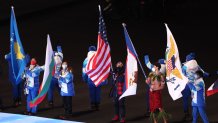 Flag bearers Elana Meyers Taylor of Team USA, center, and Nathan Crumpton of Team American Samoa (second right) walks in the Athletes Parade during the Beijing 2022 Winter Olympics Closing Ceremony on Day 16 of the Beijing 2022 Winter Olympics at Beijing National Stadium on Feb. 20, 2022 in Beijing.