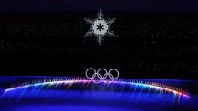 The Olympic Cauldron is seen alongside the flags of the competing countries right before it is extinguished during the 2022 Winter Olympics Closing Ceremony, Feb. 20, 2022, in Beijing.