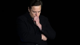 Elon Musk pauses and looks down as he speaks during a press conference at SpaceX’s Starbase facility near Boca Chica Village in South Texas on February 10, 2022.