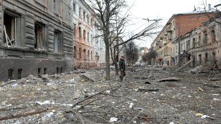 A pedestrian walks amid debris in a street following a shelling in Ukraine’s second-biggest city of Kharkiv on March 7, 2022.