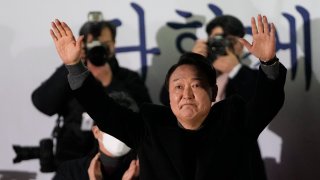 Yoon Suk Yeol, the presidential candidate of the main opposition People Power Party, raises his hands during a presidential election campaign in Seoul, South Korea, Tuesday, March 8, 2022.