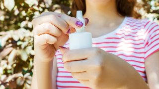 Midsection Of Woman Holding Nasal Spray While Standing In Park