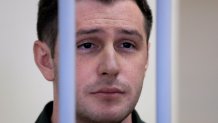 U.S. Marine veteran Trevor Reed, who was detained in 2019 and accused of assaulting police officers, stands inside a defendants' cage during a court hearing in Moscow, Russia March 11, 2020.