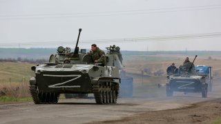Russian military vehicles move on a highway in an area controlled by Russian-backed separatist forces near Mariupol, Ukraine, Monday, April 18, 2022.