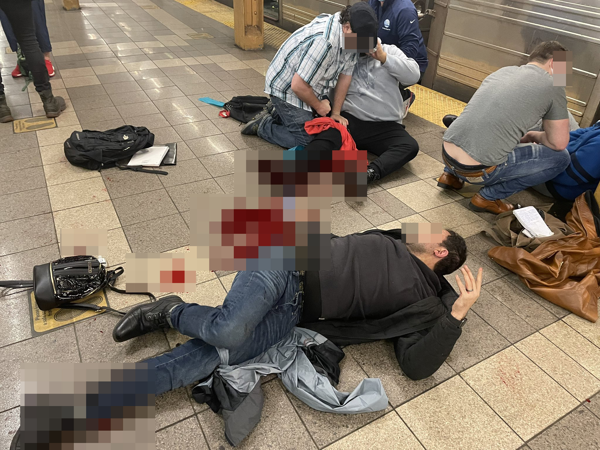 Injured subway riders seen on the platform of the 36th Street station in Brooklyn’s Sunset Park neighborhood in New York, April 12, 2022. At least five people have been shot by a man in a gas mask and orange construction vest, according to the NYPD.