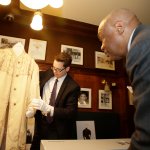 Former San Francisco Mayor Willie Brown (right) looks on as curator Kevin Jones with the Fashion Institute of Design and Merchandising, unveils a rare period coat