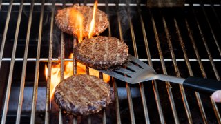 Burgers cooking on barbecue grill.
