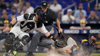 MIAMI, FLORIDA – MAY 15: Payton Henry #59 of the Miami Marlins attempts to tag Kolten Wong #16 of the Milwaukee Brewers as he slides into homeplate for a run during the seventh inning at loanDepot park on May 15, 2022 in Miami, Florida. (Photo by Mark Brown/Getty Images)