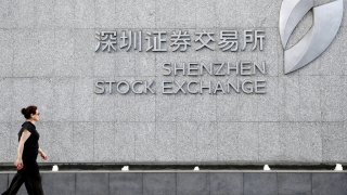 A woman walks by the gate of the Shenzhen Stock Exchange on August 20, 2020 in Shenzhen, Guangdong Province of China.