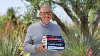 Bill Gates holds the five books he’s recommending for summer reading in 2022.