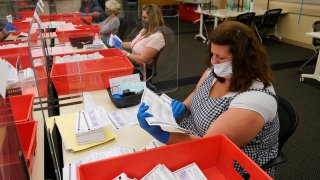 Election workers inspect ballots