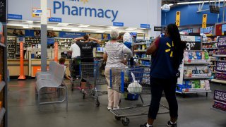 Shoppers wait in line at the pharmacy of a Walmart store in Charlotte, North Carolina.