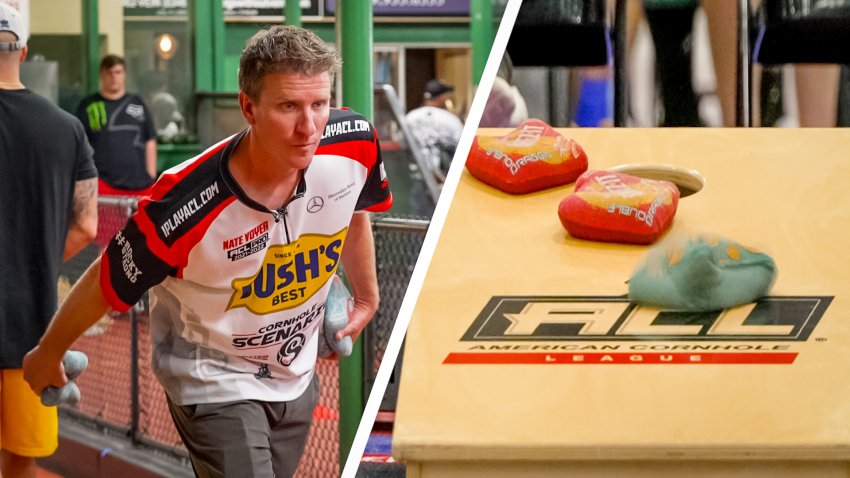 a man in a Bush's Best sponsored jersey with "Nate Voyer" printed on it gets ready to throw a bean bag on the left. On the right, a cornhole board with three bean bags already on it.