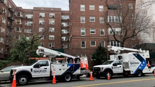 Two Spectrum maintenance trucks doing work outside apartment building, Queens, New York