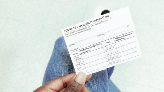 Woman Holds COVID-19 Vaccination Record Card