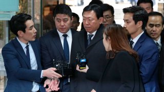 Lotte group Chairman Shin Dong-bin, center, is questioned by reporters upon arrival for his corruption trial