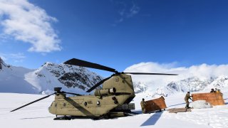FILE – Soldiers and National Park Service personnel offload equipment and supplies from a U.S. Army CH-47 Chinook helicopter on Kahiltna Glacier on April 27, 2022.