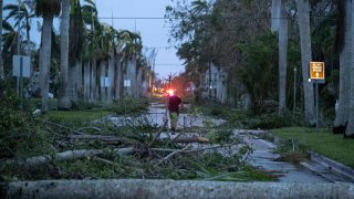 A man walks through the debris on a street in the aftermath of Hurricane Ian in Punta Gorda, Florida.