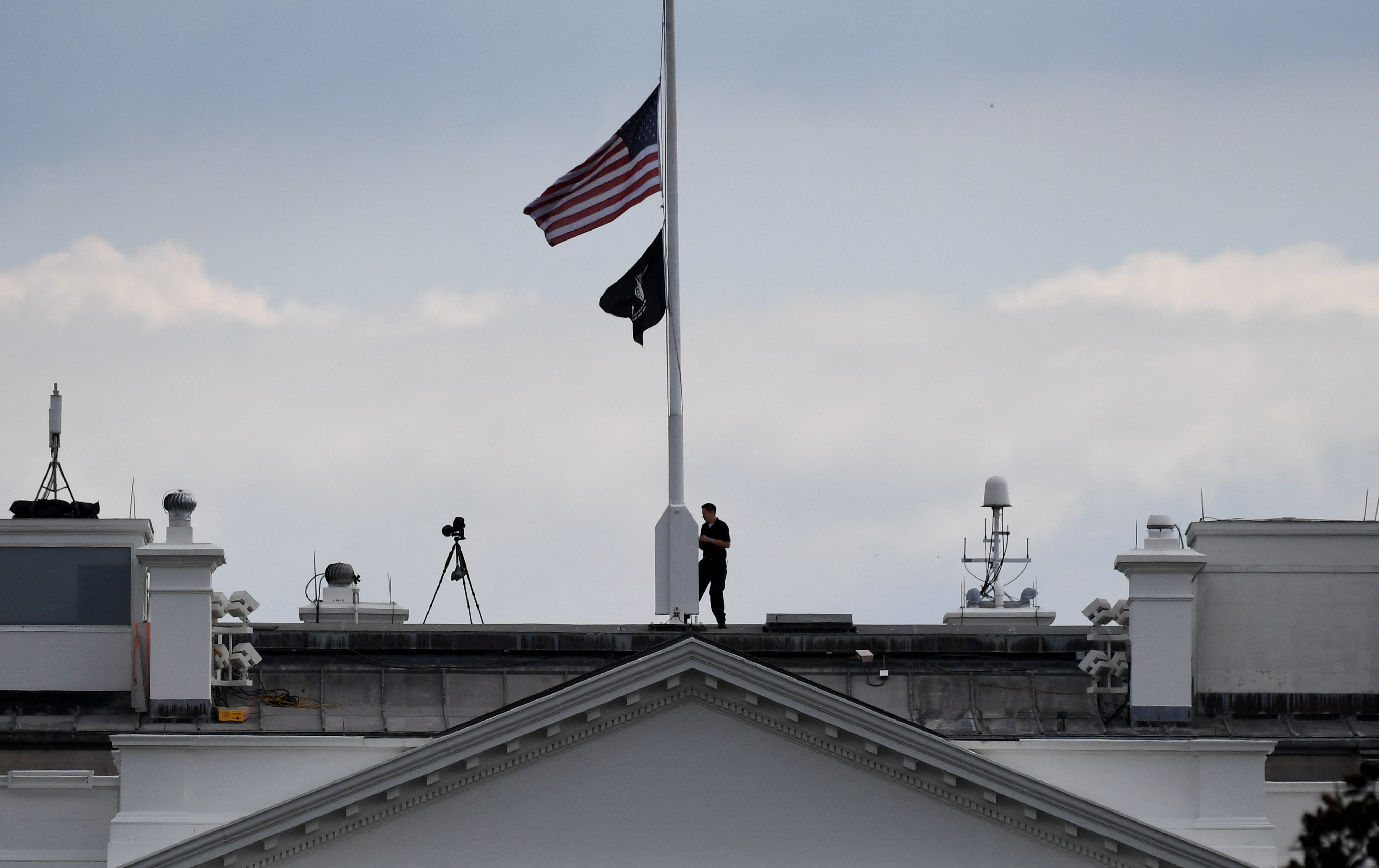 A man lowers the White House U.S. flag to half-mast in Washington, D.C, Sept. 8, 2022, following the death of Queen Elizabeth II.