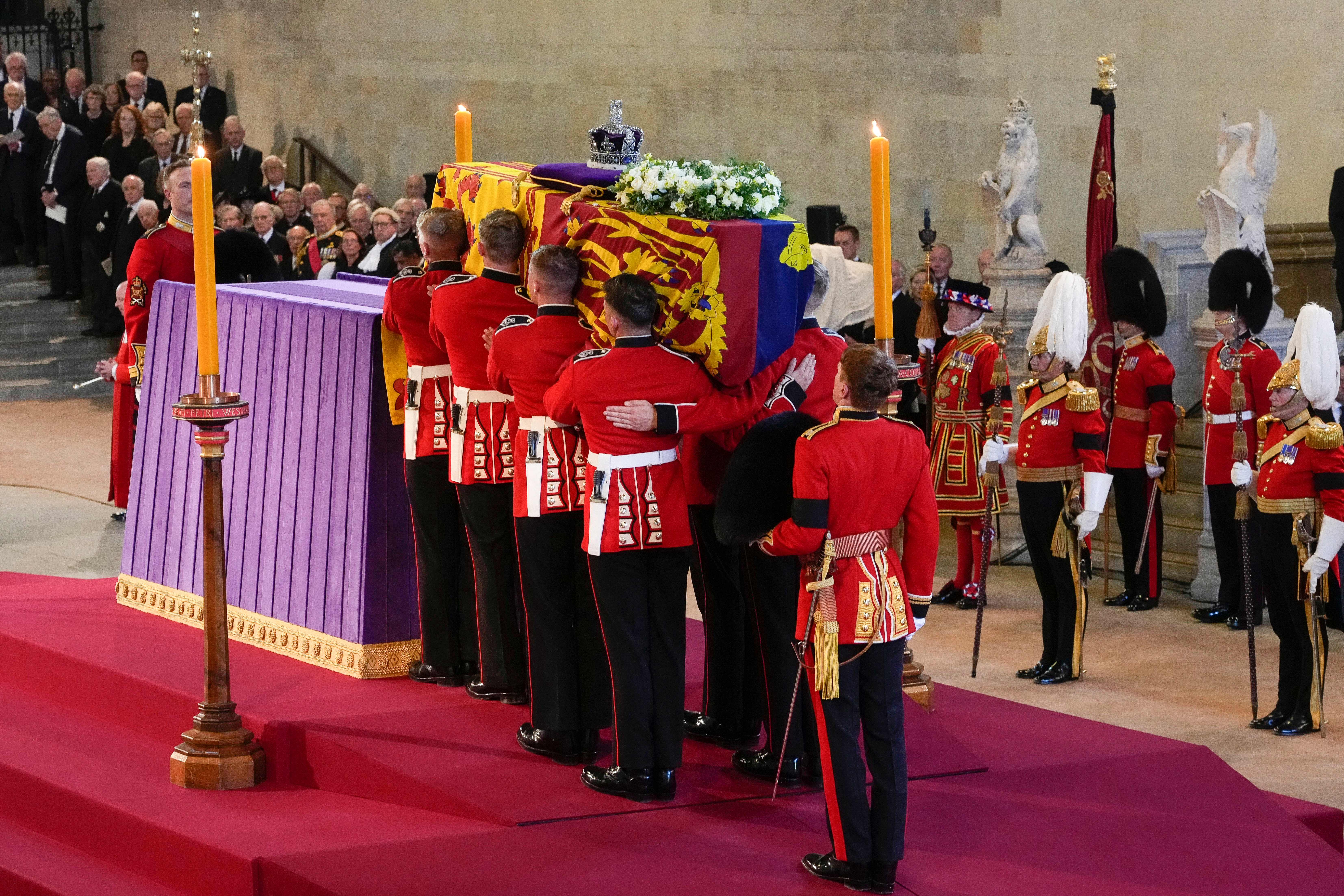 Pallbearers from The Queen’s Company, 1st Battalion Grenadier Guards, prepare to place the coffin of Britain’s Queen Elizabeth II on a catafalque inside Westminster Hall, at the Palace of Westminster, Sept. 14, 2022, London.