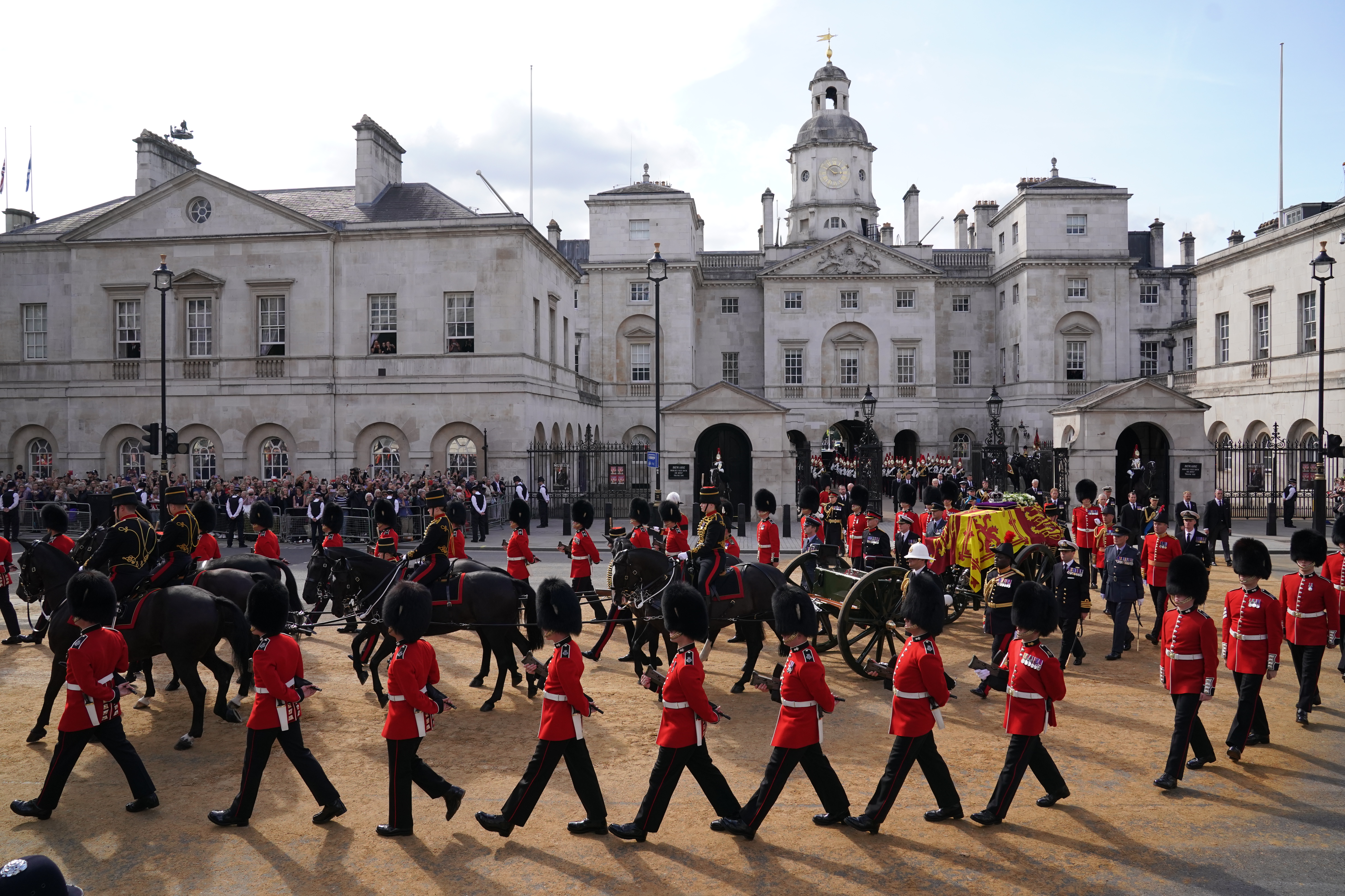 The coffin of Queen Elizabeth II, draped in the Royal Standard with the Imperial State Crown placed on top, is carried on a horse-drawn gun carriage of the King’s Troop Royal Horse Artillery, during the ceremonial procession from Buckingham Palace to Westminster Hall, London, Sept. 14, 2022.