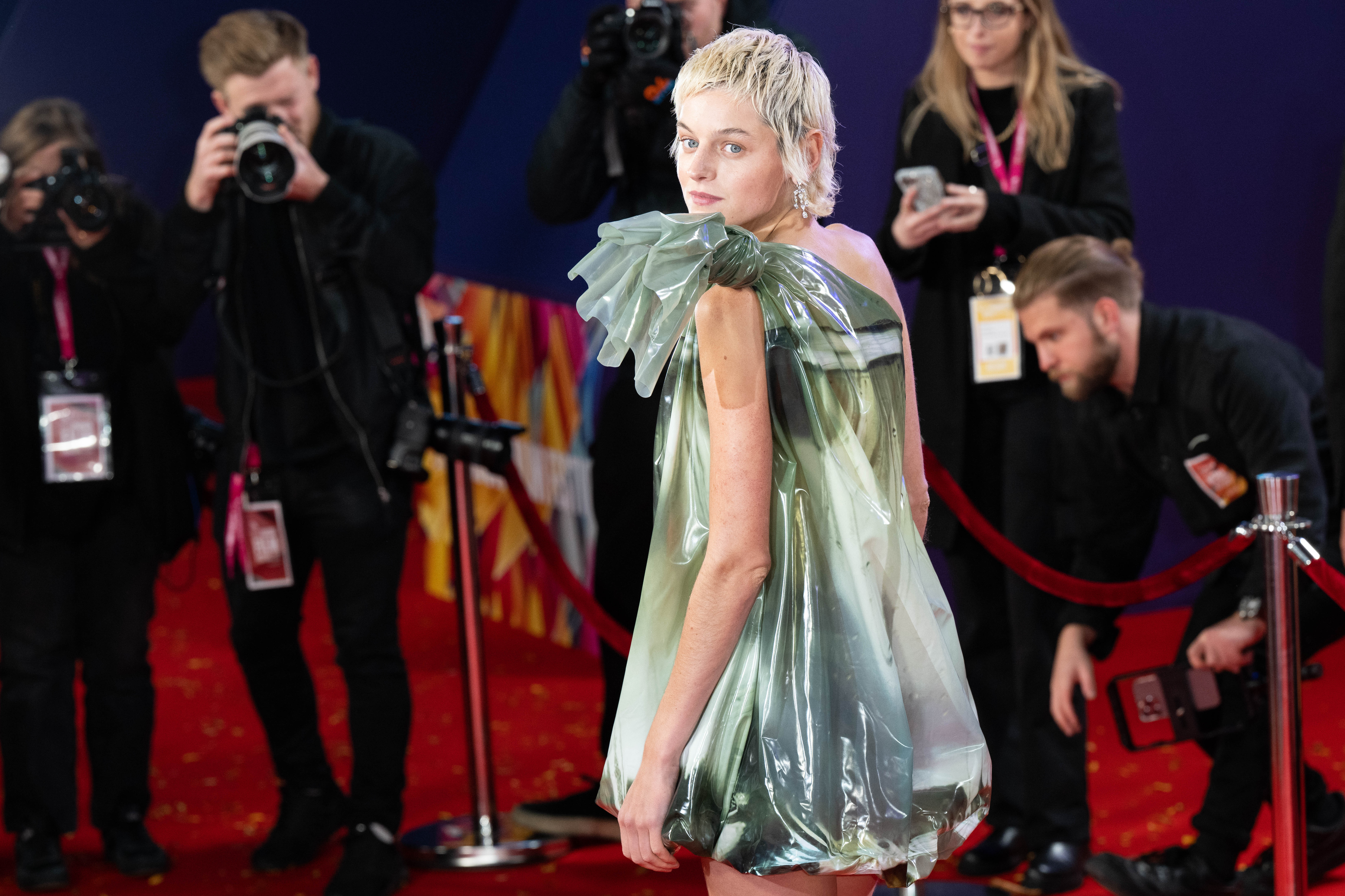 See ‘The Crown’ Star Emma Corrin’s Goldfish Bag Dress on the Crimson Carpet