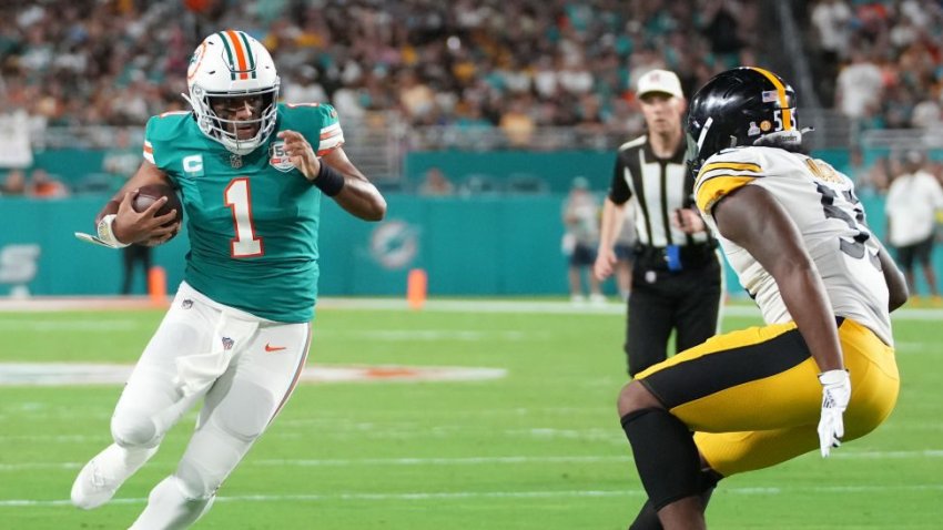 MIAMI GARDENS, FLORIDA – OCTOBER 23: Tua Tagovailoa #1 of the Miami Dolphins runs the ball against Devin Bush #55 of the Pittsburgh Steelers during the first quarter at Hard Rock Stadium on October 23, 2022 in Miami Gardens, Florida. (Photo by Eric Espada/Getty Images)