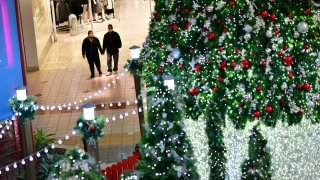 Shoppers hold hands at the Willow Grove Park Mall in Willow Grove, Pennsylvania, November 14, 2020.