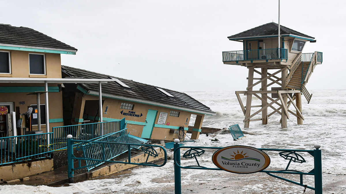 DAYTONA BEACH SHORES, UNITED STATES – 2022/11/09: Waves crash near a damaged building and a lifeguard tower in Daytona Beach Shores in Florida, as tropical Storm Nicole approaches the coast of Florida with an expected landfall as a category one hurricane. (Photo by Paul Hennessy/SOPA Images/LightRocket via Getty Images)