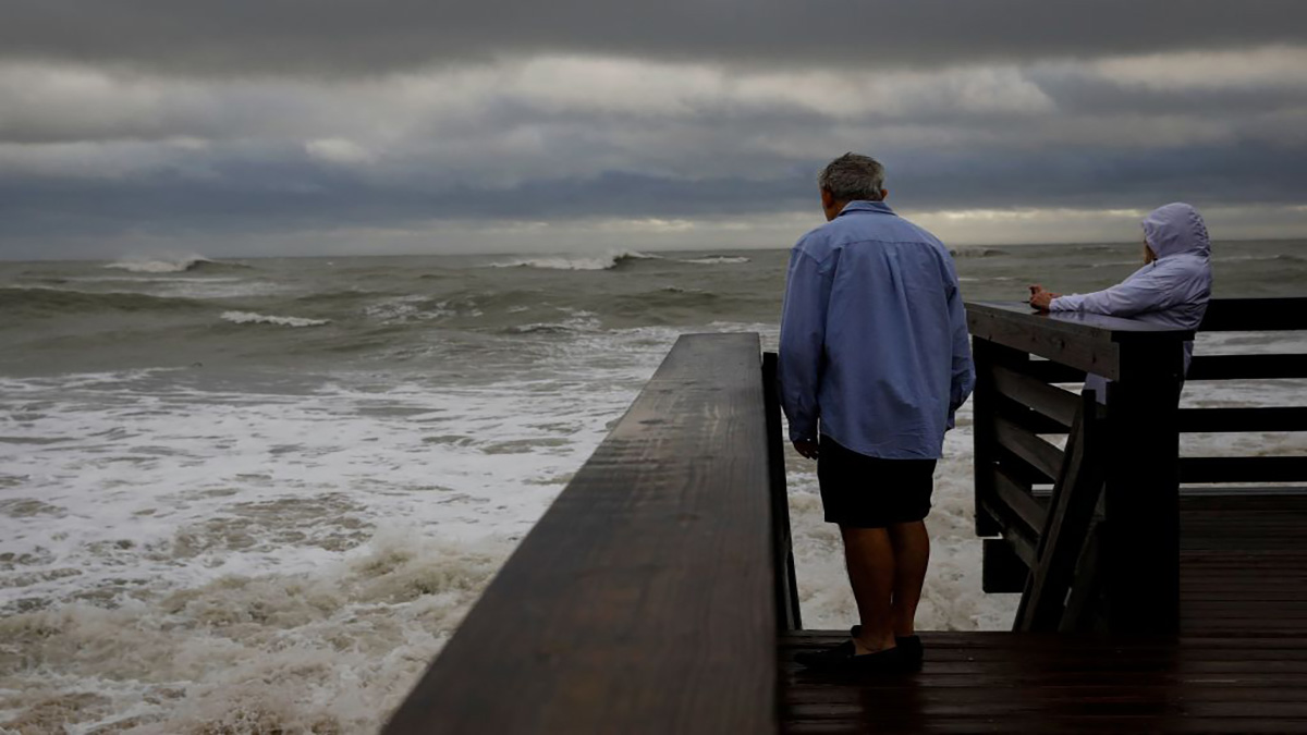 People look on from one of the access to the beach after Hurricane Nicole landfall at Vero Beach, Florida, on November 10, 2022. – Tropical Storm Nicole slowed after making landfall in the US state of Florida, meteorologists said Thursday, with high winds raising concerns that a long-delayed NASA rocket launch could be disrupted. (Photo by Eva Marie UZCATEGUI / AFP) (Photo by EVA MARIE UZCATEGUI/AFP via Getty Images)