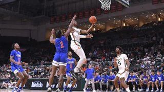 CORAL GABLES, FL – NOV 23: Miami forward Anthony Walker (1) puts up a basket in the first half while guard Harlond Beverly (5), St. Francis guard Zion Bethea (1), guard Larry Moreno (5) and forward Josiah Harris (11) look on as the Miami Hurricanes faced the St. Francis Terriers on November 23, 2022, at the Watsco Center in Coral Gables, Florida. (Photo by Samuel Lewis/Icon Sportswire via Getty Images)