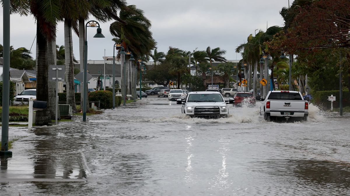 FORT PIERCE, FLORIDA – NOVEMBER 10: Vehicles drive through a flooded street after Hurricane Nicole came ashore on November 10, 2022 in Fort Pierce, Florida. Nicole came ashore as a Category 1 hurricane before hitting Florida’s east coast. (Photo by Joe Raedle/Getty Images)