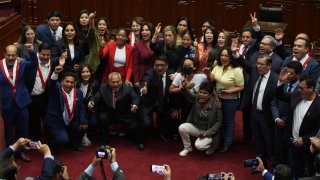 Lawmakers pose for photos as they celebrate after verbally voting to remove President Pedro Castillo from office in Lima, Peru, Wednesday, Dec. 7, 2022.