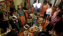 Friends and family join hands to share Kwanzaa blessings before eating special dishes prepared by Maisie McNaught at her home in Miami Gardens, Florida, December 6, 2007. (Photo by John VanBeekum/Miami Herald/Tribune News Service via Getty Images)