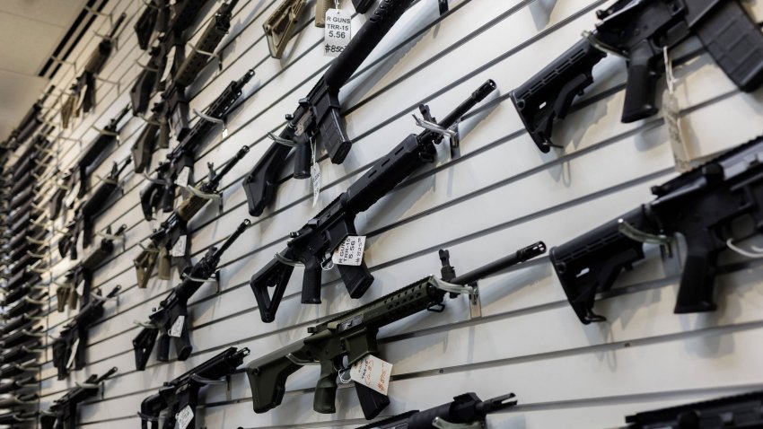 A selection of AR-15-style rifles hangs on a wall at R-Guns store on Jan. 11, 2023, in Carpentersville, Illinois, a day after the state ban.