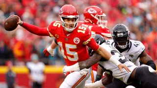 Patrick Mahomes #15 of the Kansas City Chiefs scrambles against Devin Lloyd #33 of the Jacksonville Jaguars during the first quarter in the AFC Divisional Playoff game at Arrowhead Stadium on January 21, 2023 in Kansas City, Missouri.