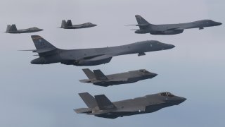 In this photo provided by South Korean Defense Ministry, U.S. Air Force B-1B bombers, center, F-22 fighter jets and South Korean Air Force F-35 fighter jets, bottom, fly over South Korea Peninsula