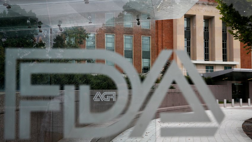 FILE - The U.S. Food and Drug Administration building behind FDA logos at a bus stop on the agency's campus in Silver Spring, Md., on Aug. 2, 2018.