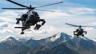 In this file photo released by the U.S. Army, AH-64D Apache Longbow attack helicopters from the 1st Attack Battalion, 25th Aviation Regiment, fly over a mountain range near Fort Wainwright, Alaska, on June 3, 2019.