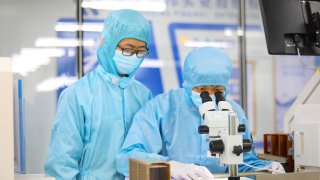 CHONGQING, CHINA – MAY 4, 2023 – Young technicians test the quality of electronic chips at a dust-free production workshop in Chongqing, China, May 4, 2023.