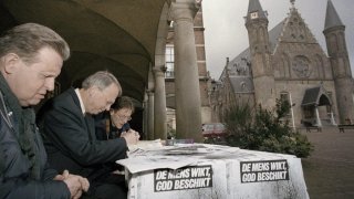 FILE – Protesters pray outside Dutch government buildings in The Hague, Netherlands, on Monday, April 9, 2001, as the Upper House of Parliament began debating registration that will legalize euthanasia under strict guidelines. Slogan on table reads, “Human considers, God decides.” Several people with autism and intellectual disabilities have been legally euthanized in the Netherlands in recent years because they said they could not lead normal lives, researchers have found. The Netherlands was the first country to allow doctors to kill patients at their request if they met strict requirements. (AP Photo/Serge Ligtenberg, File)
