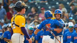 BT Riopelle #15 of the Florida Gators celebrates with Tucker Talbott #32 after hitting a home run as Jared Jones #22 of the LSU Tigers looks on during the ninth inning of Game 2 of the NCAA College World Series baseball finals.