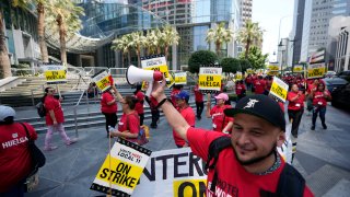 Striking hotel workers rally outside the Intercontinental Hotel after walking off their job early Sunday, July 2, 2023, in downtown Los Angeles. (AP Photo/Damian Dovarganes)