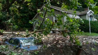 A car is buried in flood debris from recent storms and flooding on July 17, 2023, in Belvidere, New Jersey.