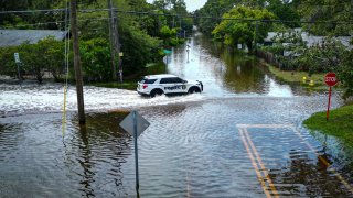 An aerial view shows a police vehicle driving along a flooded street in New Port Richey, Florida, after Hurricane Idalia made landfall, Aug. 30, 2023.