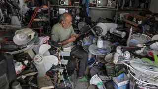 Palestinian Mustafa Abdo, 75-years old, repairs a fan at his shop amid a heat wave at Shati refugee camp. Abdo has been working in the maintenance of electrical appliances for more than 30 years, until now.