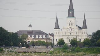 The low water level of the Mississippi River is seen as people sit on steps that normally meet the river near St. Louis Cathedral in the French Quarter