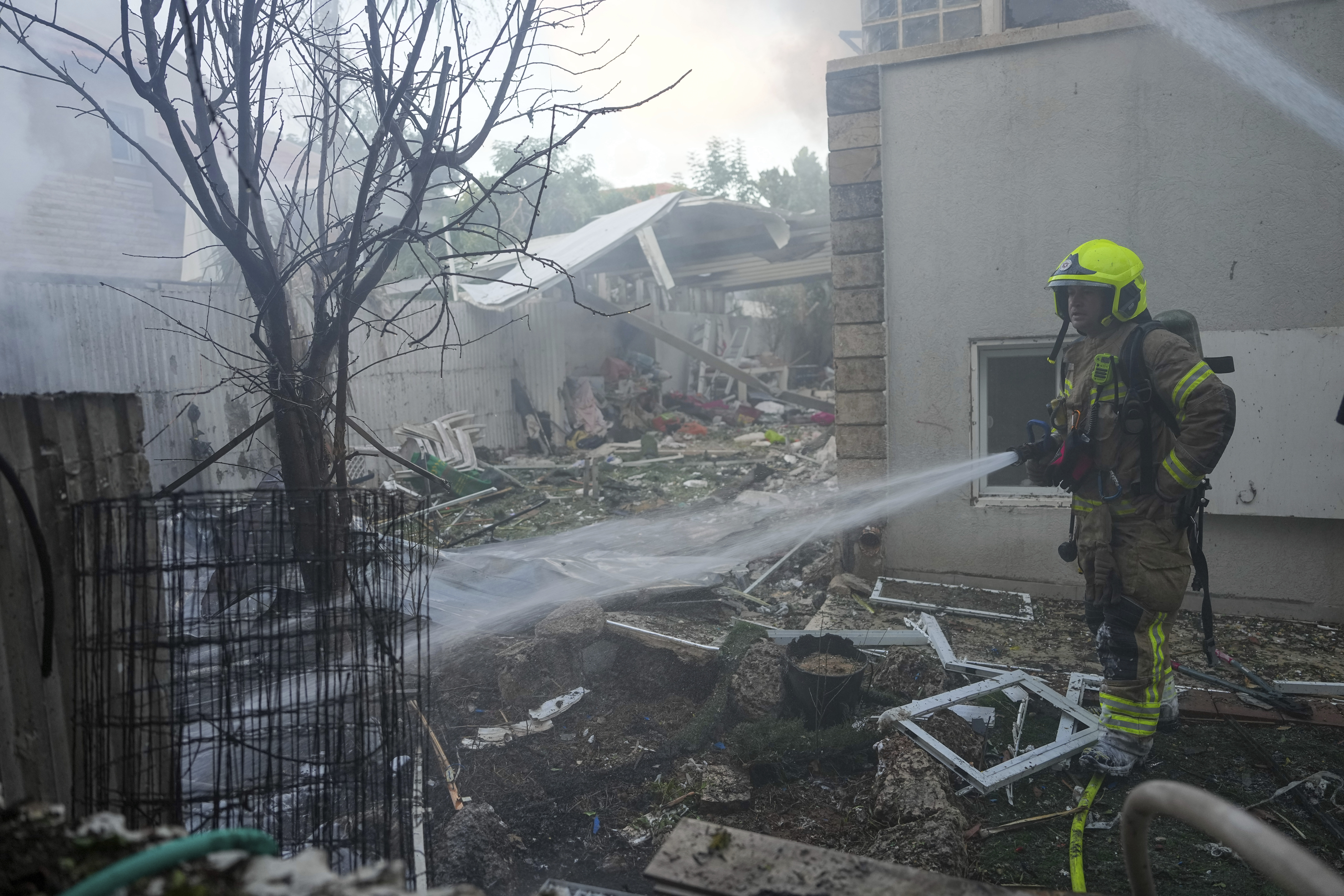 Israeli firefighters extinguish fire after a rocket fired from the Gaza Strip hit a house in Ashkelon, southern Israel, Saturday, Oct. 7, 2023.