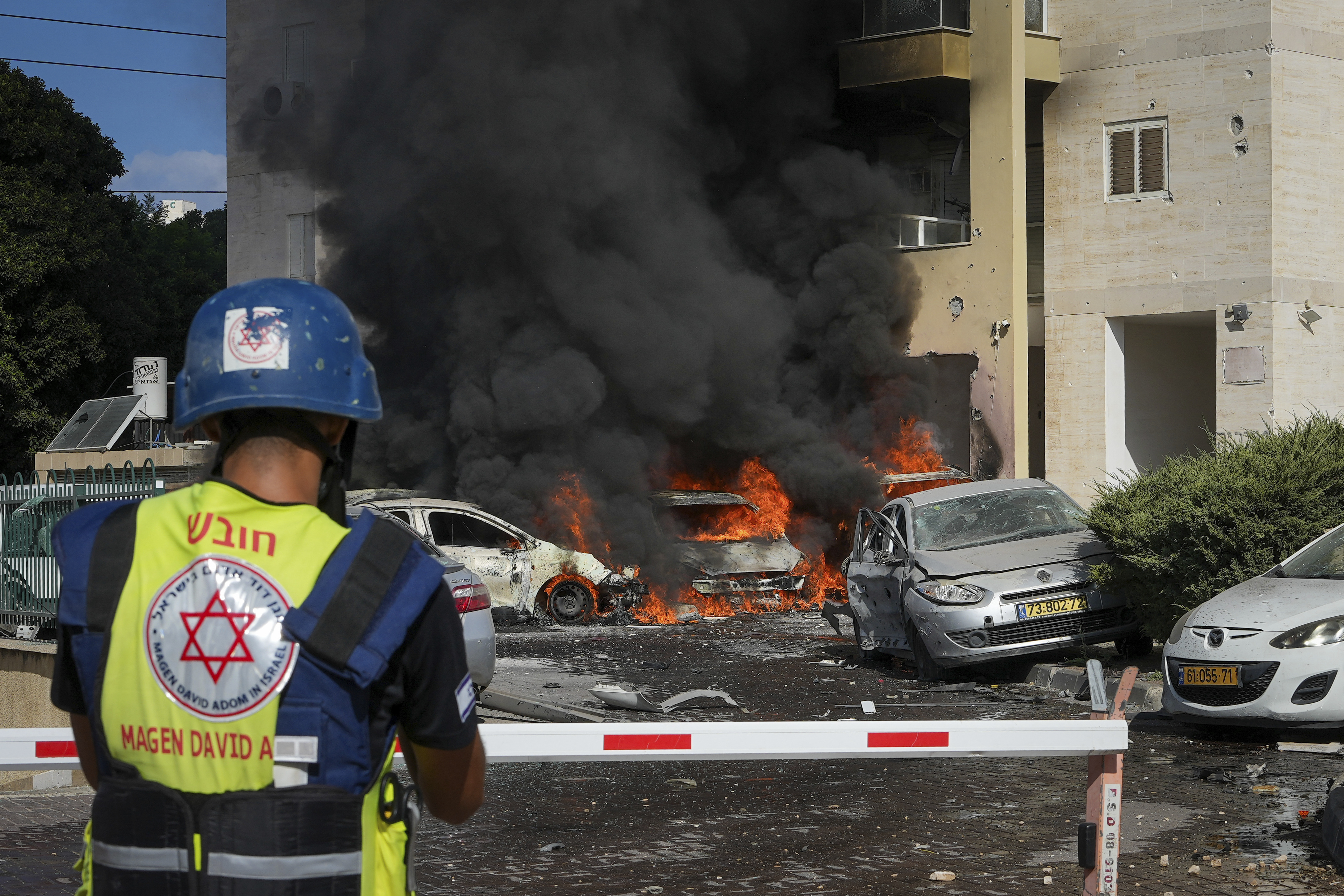 Cars burn after a rocket fired from the Gaza Strip hit a parking lot and a residential building in Ashkelon, southern Israel, Saturday, Oct. 7, 2023.